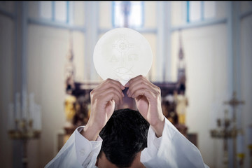 Pastor hand raises a communion bread in church