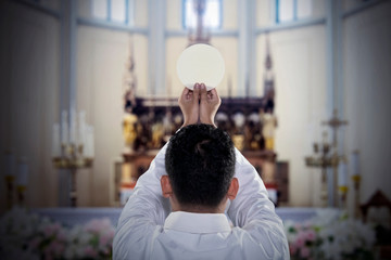 Pastor with sacramental bread in the church