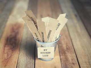 Wall Mural - Motivational and inspirational concept - My Bucket List written on paper. There are list of wishes written on papers and placed inside the bucket. Blurred vintage styled background.