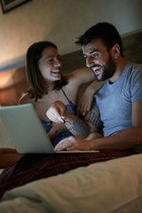 Wall Mural - couple having fun relaxing on bed at home in night time enjoying.