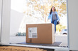 © Monkey Business - Woman Coming Back To Home Delivery In Cardboard Box Outside Front Door