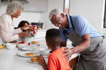 Wall Mural - Grandparents In Kitchen With Grandchildren Making Pancakes Together