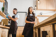© LIGHTFIELD STUDIOS - barista and cashier in aprons standing behind bar counter in coffee house