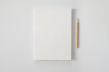 A Stack Of Blank Sheets Of Paper And A Pencil On A White Background