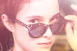 a young girl looks out from under the glasses in a leopard frame