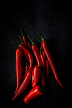 Fresh Red And Spicy Chilli Peppers On Dark Background. Flat Lay. From Above