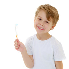 Wall Mural - A little boy is brushing his teeth with a toothbrush.