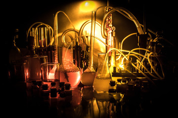 Pharmacy and chemistry theme. Test glass flask with solution in research laboratory. Science and medical background. Laboratory test tubes on dark toned background