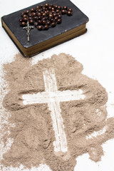 Wall Mural - Old Bible, rosary and Cross of ash on white background - symbols of Ash Wednesday.