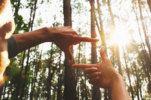 Hands Framing Distant Over View Sun In Forest