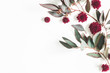 Flowers composition. Eucalyptus leaves and red flowers on white background. Flat lay, top view, copy space