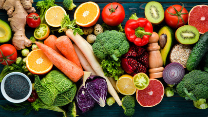 Wall Mural - Healthy organic food on a blue wooden background. Vegetables and fruits. Top view. Free copy space.