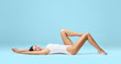© Acronym - Athletic and healthy girl posing in white bodysuit. Fit and sexy woman in underwear swimsuit. Slim shape, nutrition, sport, fitness and diet concept.