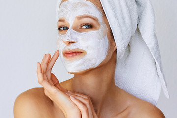 Wall Mural - beautiful young woman with facial mask on her face. skin care and treatment, spa, natural beauty and
