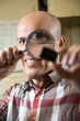 © caftor - middle-aged worker holding a magnifying glass