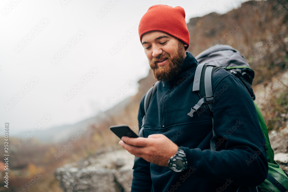 Young bearded man smiling and sending messages for his family from his ...