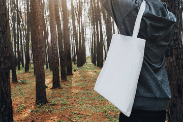 Wall Mural - people holding cotton bag for mockup blank in nature background