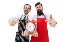 Time To Cook. Men Pointing At Alarm Clock. Man Bearded Hipster And Mature Chef Apron White Background. Cook Dinner. We Going To Cook Right Now. Friends Colleagues Start Cooking Just On Time