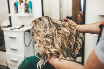 Beautiful hairstyle of mature woman after dying hair and making highlights in hair salon.