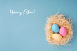 Happy Easter greeting card; Colored eggs in a hen nest.