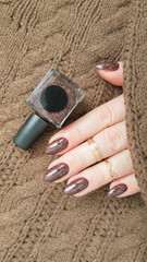 Female hands with long nails with brown nail polish