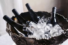 Closeup And Selective Focus Of Wine And Champagne Bottles Chilling In A Bucket Full Of Ice.