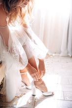 Bride Puts On Her Wedding Shoes In Natural Sunlight