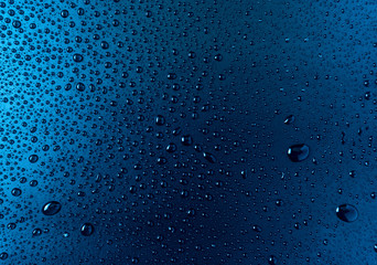 Drops of water on a blue glass texture background