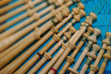 fuseaux de dentellière en gros plan sur fond bleu