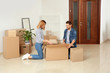 © New Africa - Happy couple unpacking moving box in their new house
