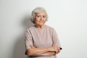 Wall Mural - Portrait of elderly woman on light background