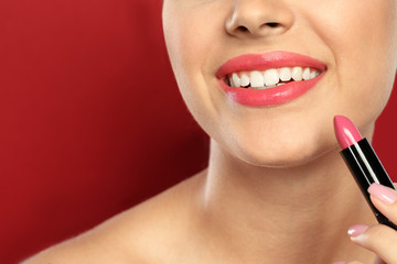 Sticker - Young woman applying lipstick on color background, closeup