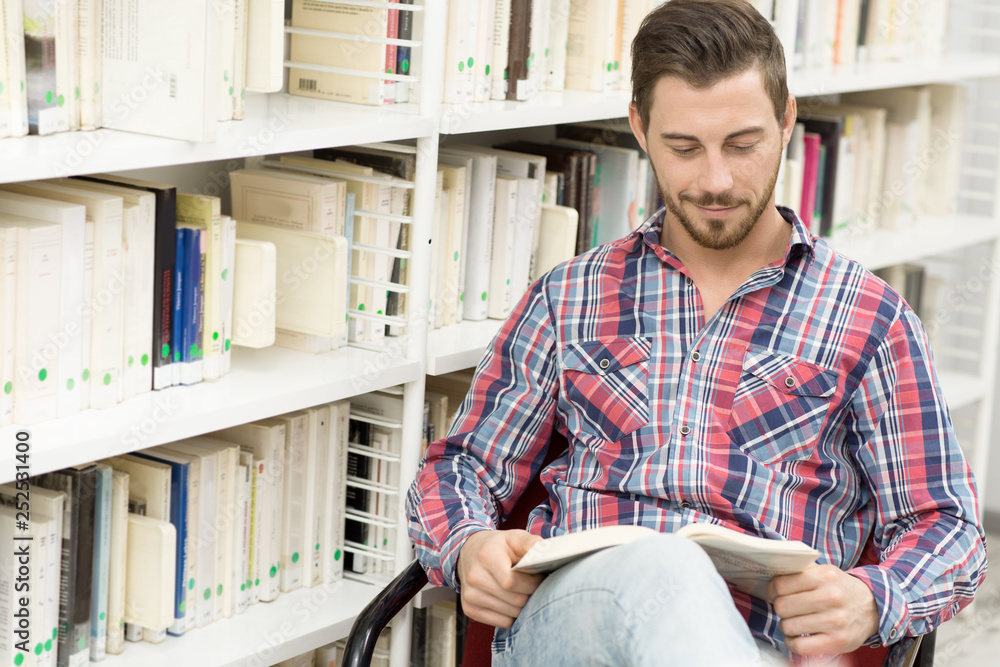 Guy In Library Handsome young man studying at the library Stock Photo | Adobe Stock
