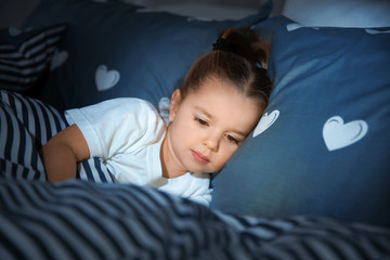 Canvas Print - Beautiful little girl with gadget in bed at night. Bedtime schedule