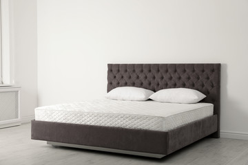 Sticker - Comfortable bed with new mattress near wall in room. Healthy sleep