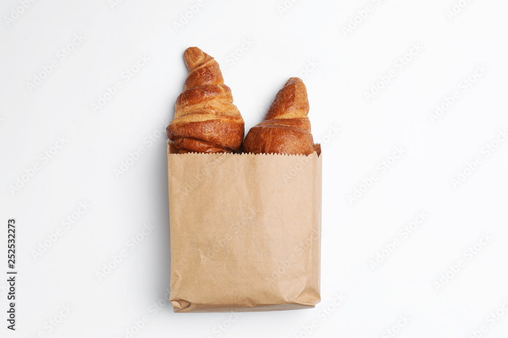 Paper bag with croissants on white background, top view. Space for ...