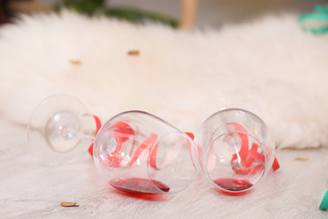 Overturned wineglasses on messy floor indoors. After party chaos