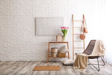 Canvas Print - Stylish living room interior with cozy armchair near brick wall. Space for text