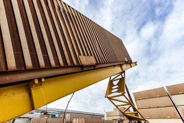 Contenedor descargando levantado sobre plataforma realizando operaciones de trasvase para cargar camión silo cisterna en puerto seco