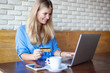 © olezzo - Woman  with laptop  and credit card in cafe . Online payment, digital banking. Young girl  shopping online.