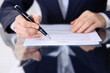 © rogerphoto - Unknown female hands with pen over document of contract. Agreement signing or business concept