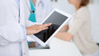 © rogerphoto - Doctor woman using tablet computer, close-up of hands at touch pad screen. Medicine concept