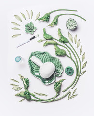 Wall Mural - spa composing with herbal massage stamp in green tropical bowl with leaves and flowers on white tabl
