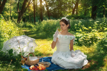 girl in a wedding dress in the park on a sunny day on a picnic with