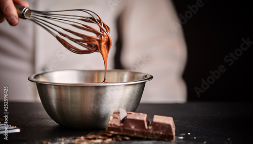Cuadros en Lienzo Baker or chef whisking melted chocolate in a bowl
