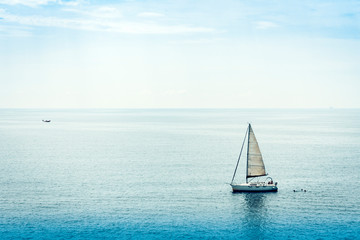  Sail boat in sea near Acitrezza rocks of the Cyclops, Catania, Sicily, Italy.