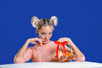 Wall Mural - Beautiful young girl with basket of Easter eggs on colored background.