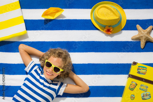 Top view portrait of child on striped beach towel