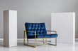 © Photographee.eu - Velvet petrol blue armchair between two white blocks of wood