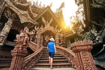 A man tourist is sightseeing inside the Ancient wooden Sanctuary of Truth in Pattaya, Thailand.